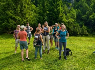 Gruppe von Retreat-Teilnehmern inmitten einer grünen Berglandschaft