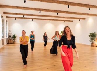 Gruppe beim gemeinsamen Salsa-Tanzen in einem Seminarraum